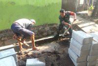 Anggota Koramil 0819/18 Pandaan Sertu M Syukron saat melaksanakan Karya bakti pemasangan dan pembenahan Jalan Paving (foto: ist)